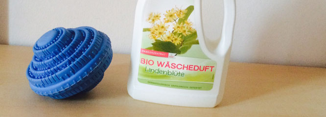 Blauer Waschball und eine Flasche Bio Wäscheduft